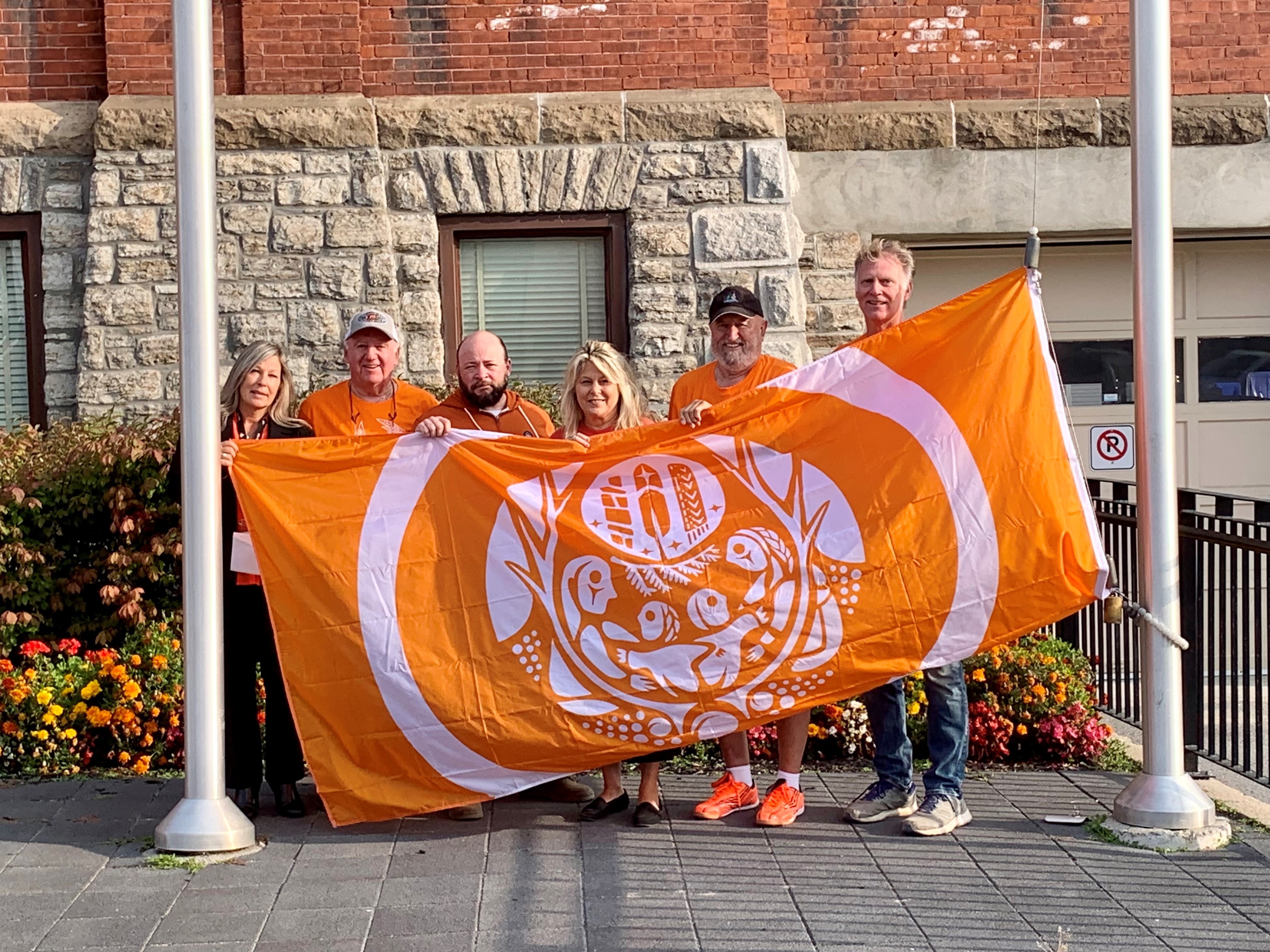 Flag raising ceremony with Members of Council holding the official flag for the National Day for Truth and Reconciliation 