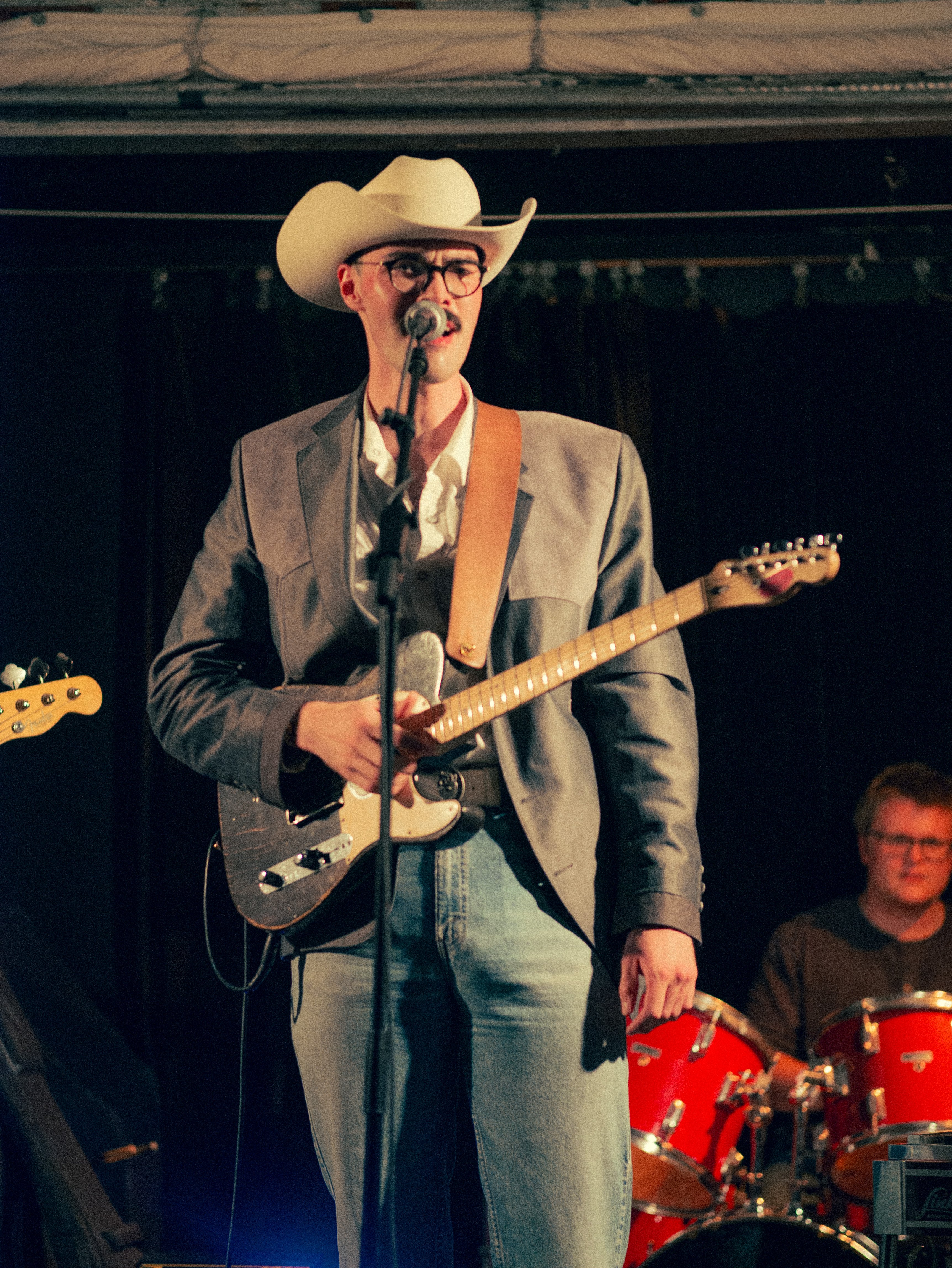 Jacob with a guitar singing in to the microphone