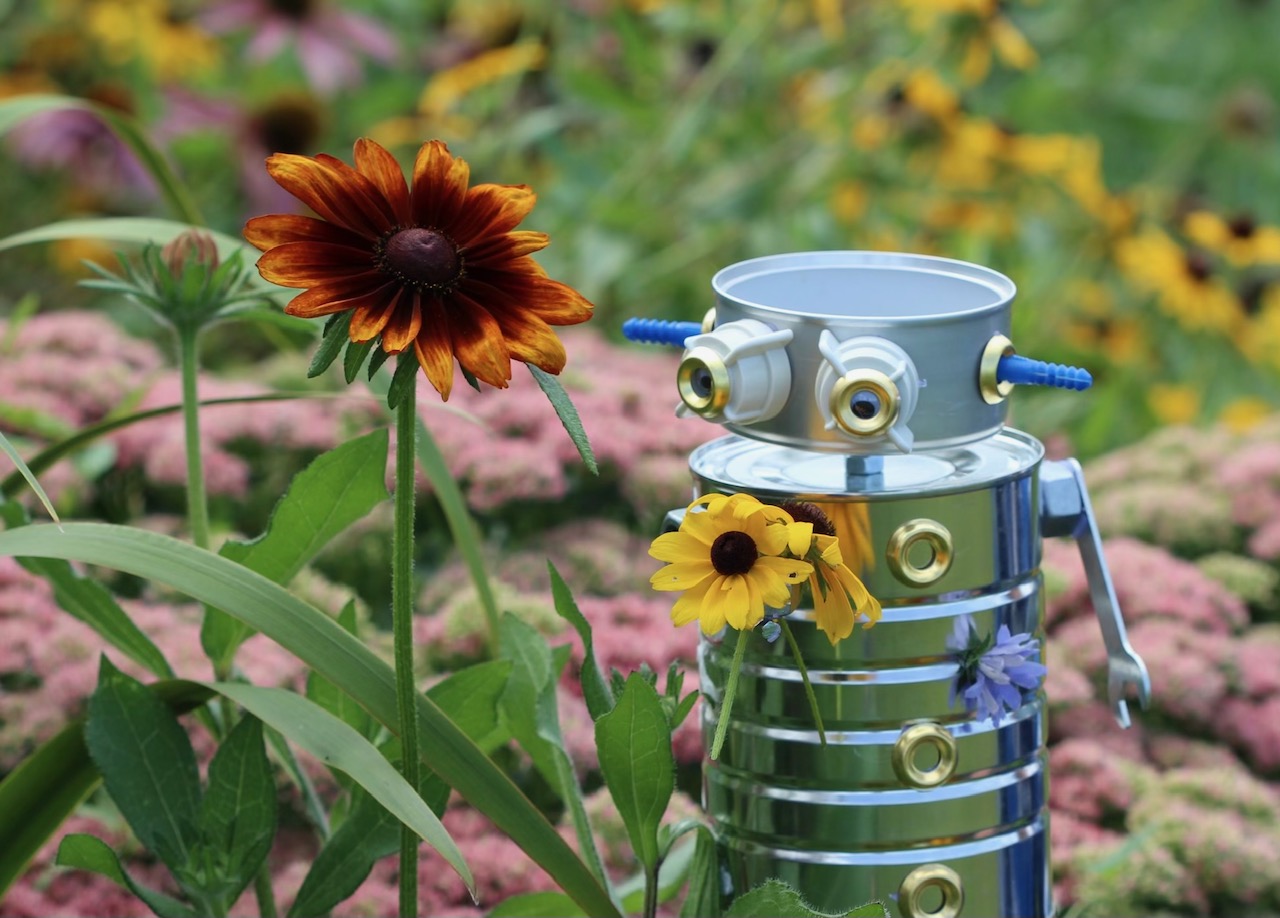 A robot in a patch of flowers