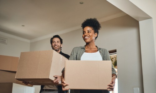 Couple carrying moving boxes