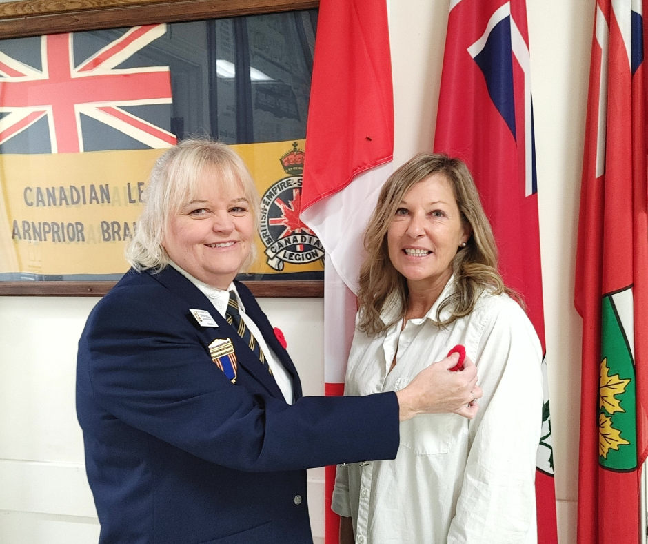 Donna Bell, President of the Legion Branch 174 pins the first poppy on Deputy Mayor Lisa McGee