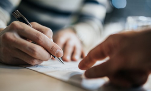 Someone being shown where to sign a document