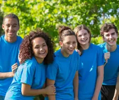 Five camp counsellors smiling at the camera 