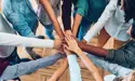 bunch of people with there hand in a circle 